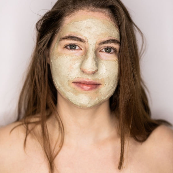 woman wearing skin repair mask and looking directly at camera