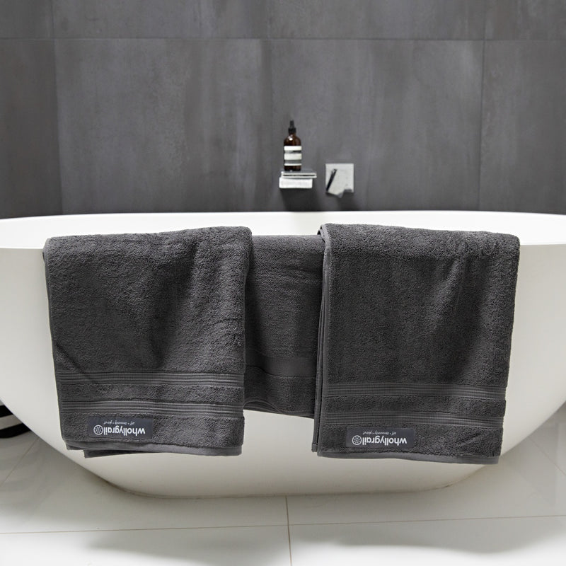 Black and white image of charcoal towels across a white bath