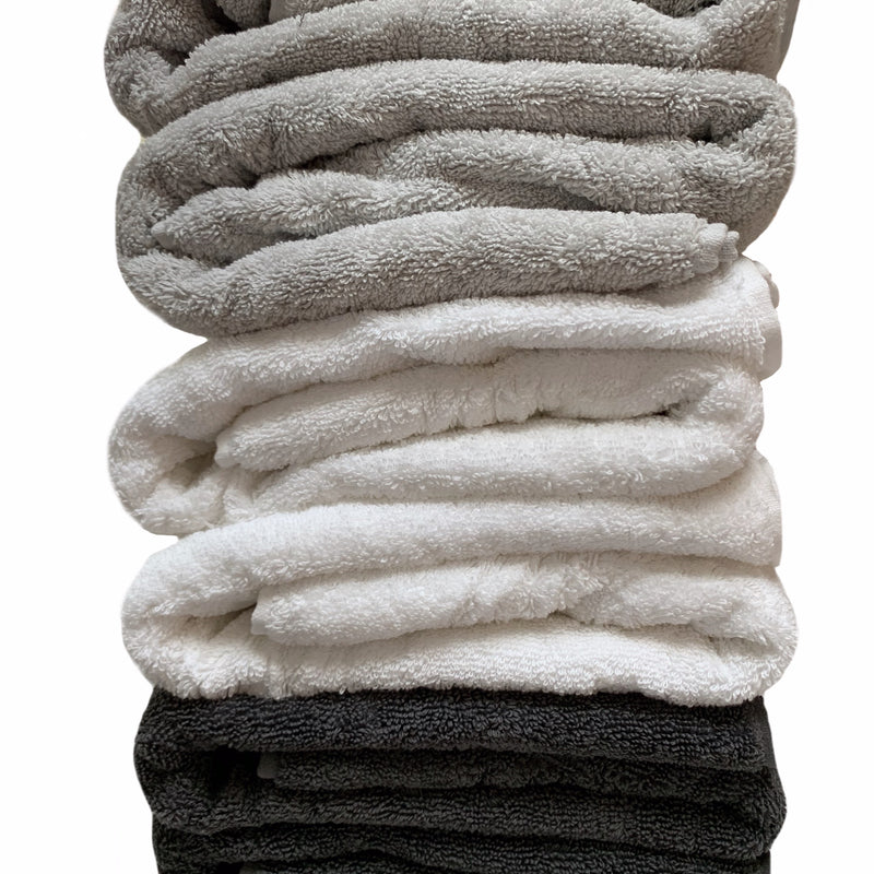 Stacked pile of folded bath towels in stone, white and charcoal